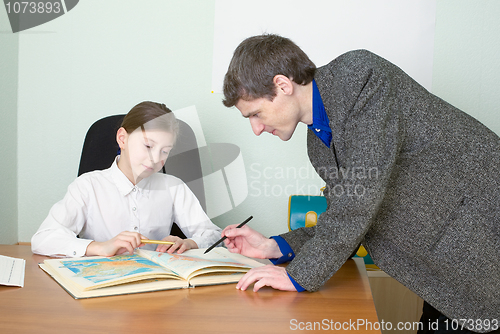 Image of Tutor and schoolgirl with atlas