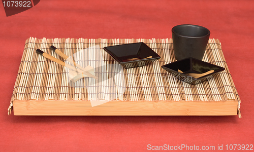 Image of Still life from tray with chinese stick's and sauce-boat