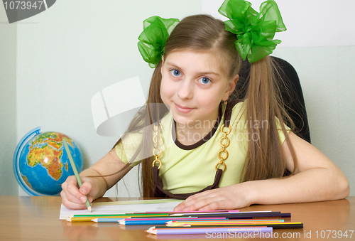 Image of Girl sitting at a table with pencils