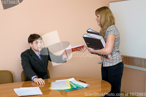 Image of Secretary gives a folders to the chief