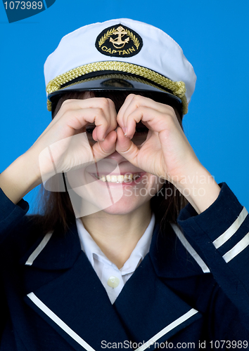 Image of Funny girl in a sea uniform emits binoculars