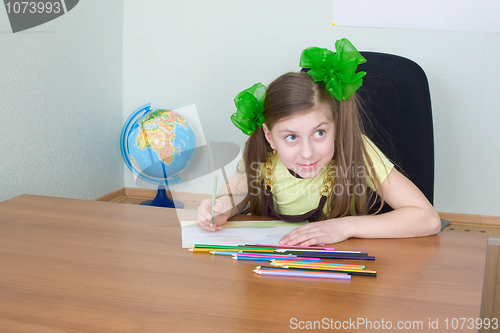 Image of Girl sitting at a table with pencils