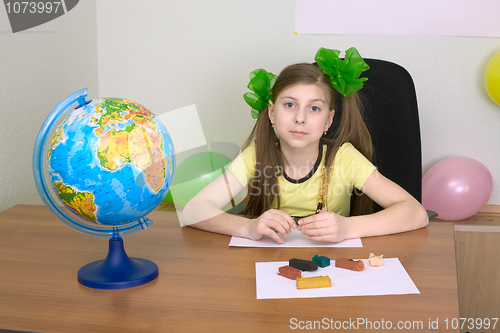 Image of Girl sitting at a table with plasticine