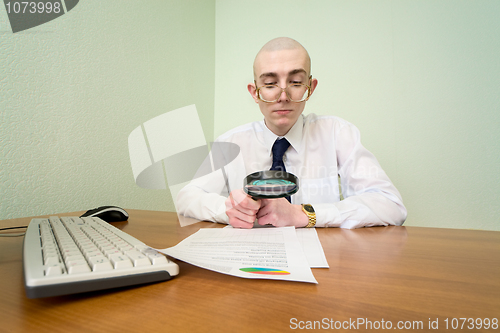 Image of Boss with a magnifier on a workplace