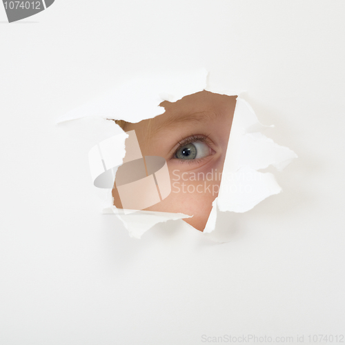 Image of Eye looking through hole in sheet of paper