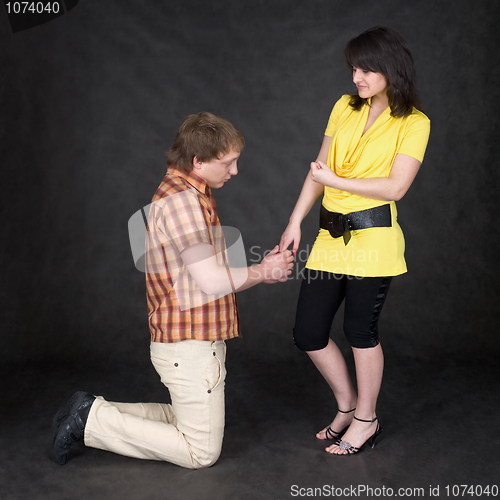 Image of Man is kneeling to the young woman, being sorry