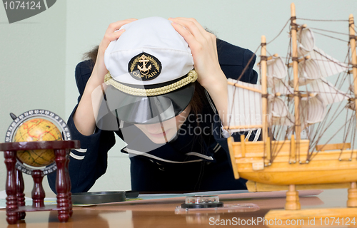 Image of Sad woman in a sea uniform at table