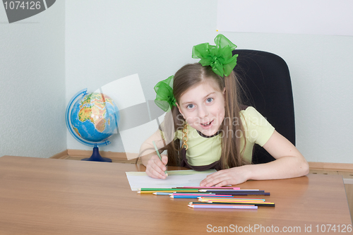 Image of Girl sitting at a table with pencils