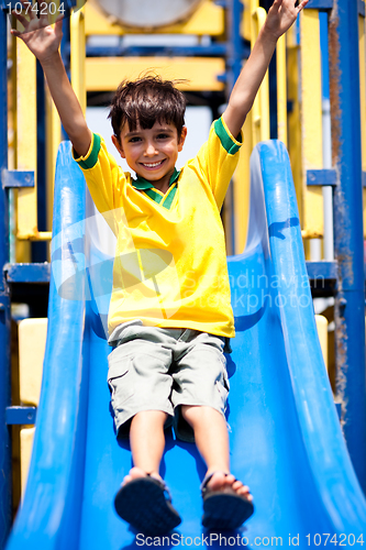 Image of Young smart kid sliding down the swing