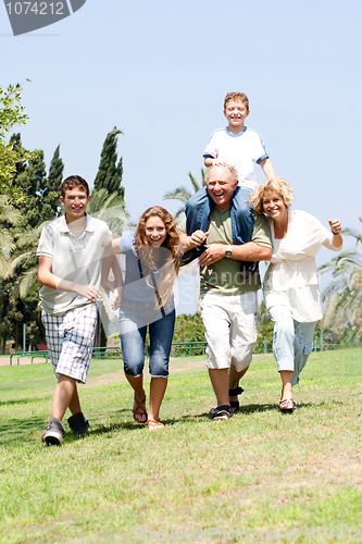 Image of Happy family playing in the park