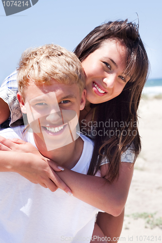 Image of Girl riding on guy at beach