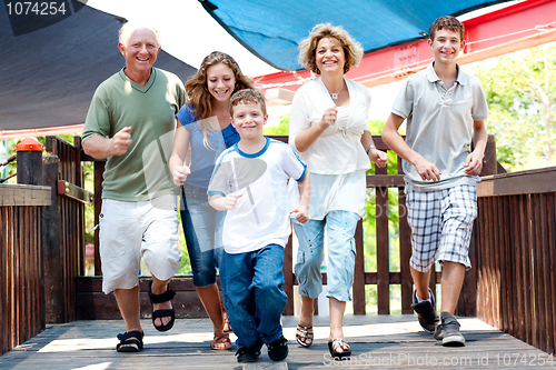 Image of Family of five running on the wooden bridge