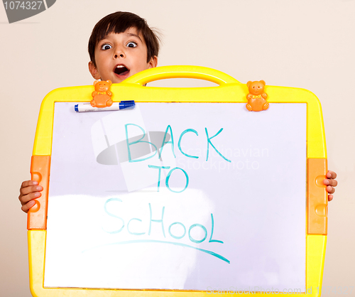 Image of Little boy holding a whitebaord