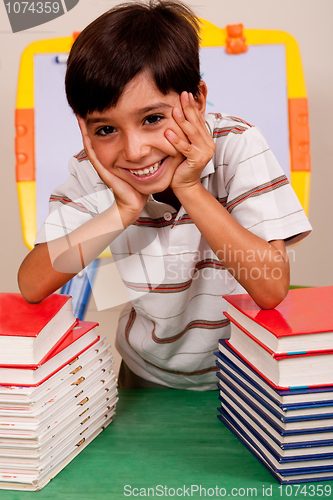 Image of Cute young boy resting on books