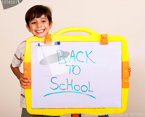 Image of Little boy smiling with a whitebaord