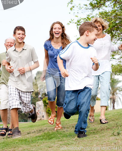 Image of Family chasing young kid in the park