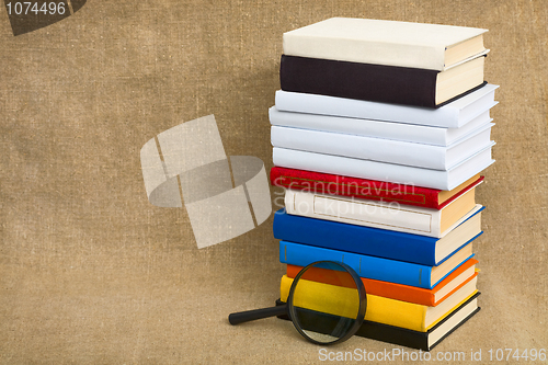 Image of Big pile of books and magnifier glass