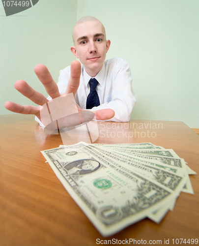 Image of Man reaches for a batch of money