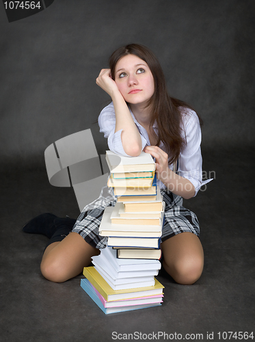 Image of Girl sits having leant the elbows on a books