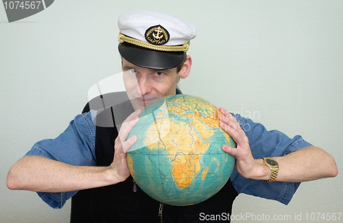 Image of Guy in a sea uniform cap with globe