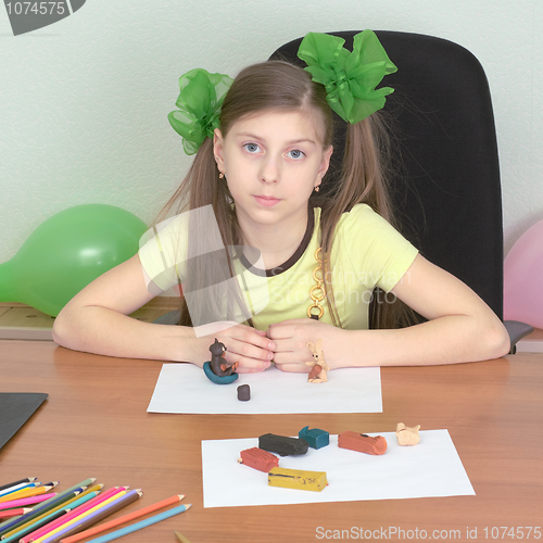 Image of Girl sitting at a table with plasticine