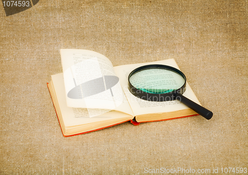 Image of Old book and magnifier glass on canvas