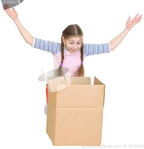 Image of Little girl joyfully looks in a box