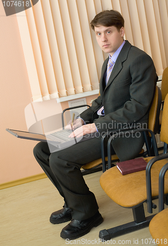 Image of Person in a suit with the laptop