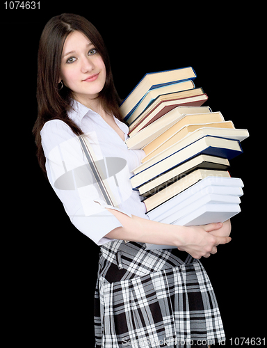 Image of Girl with a pile of books in hands on black