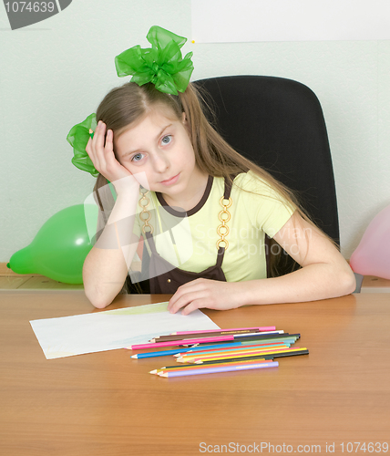 Image of Girl sitting at a table with pencils