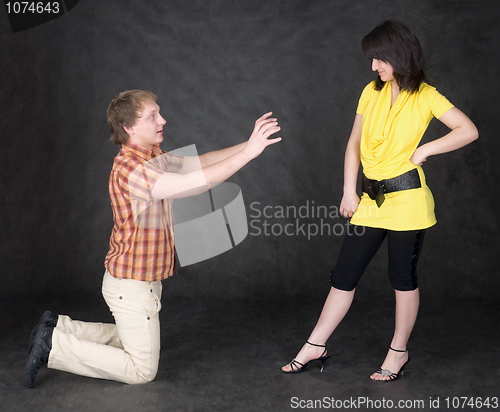 Image of Man is kneeling to the young woman