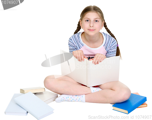 Image of Girl sits among a heap of books