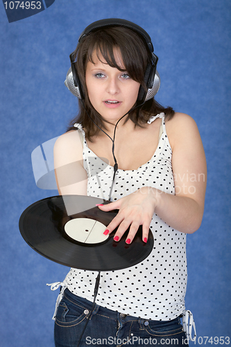 Image of Girl in ear-phones with a phonograph record