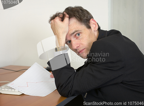 Image of Sorrowful man at the office, on a workplace