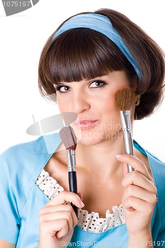 Image of woman in blue dress with two make-up brushes