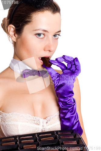Image of woman in corset and little hat eating sweets