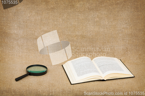 Image of Open book and magnifier on canvas