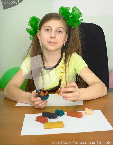 Image of Girl sitting at a table with plasticine