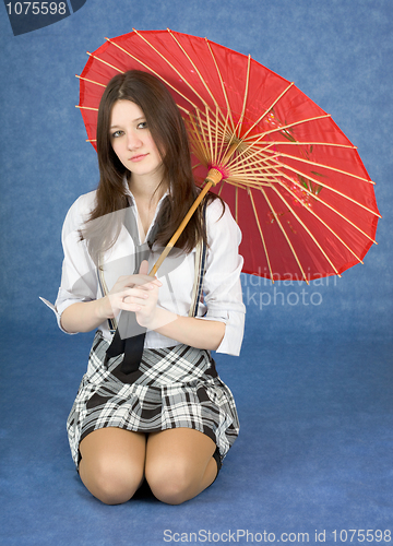Image of Beautiful girl sits with the Japanese umbrella