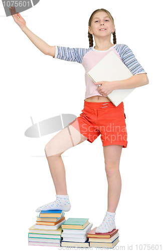 Image of Girl standing on piles of books