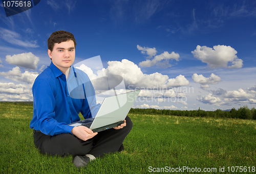 Image of Young businessman work with laptop at the field
