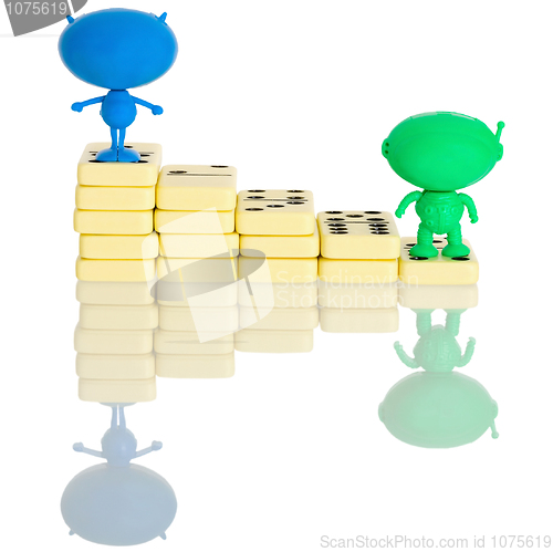 Image of Two plastic aliens on a stairs from dominoes