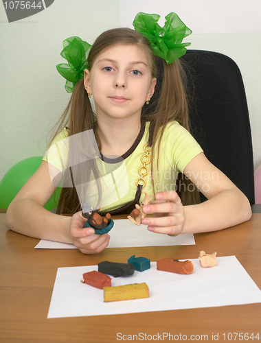 Image of Girl sitting at a table with plasticine