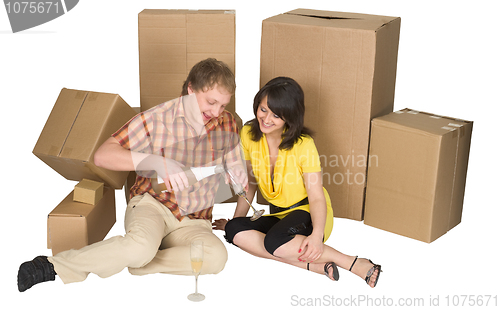 Image of Girl and the guy drink champagne near boxes