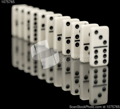 Image of Some bones of dominoes put abreast on a black