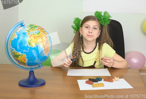 Image of Girl sitting at a table with plasticine