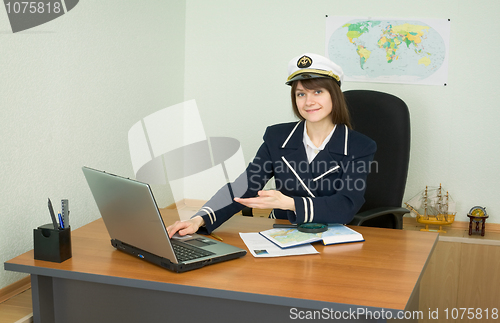 Image of Girl in a sea uniform at table with laptop