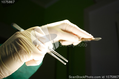 Image of Hand with tweezers and sclapel