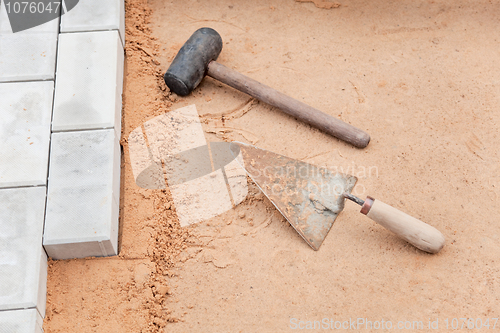 Image of Tools of the mason on a sand - trowel and hammer