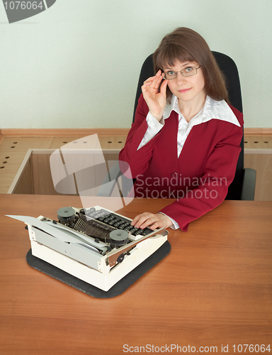 Image of Young girl in office armchair with typewriter
